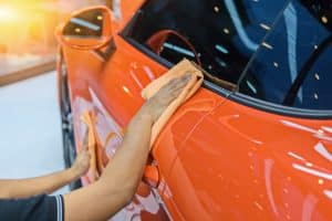 Ceramic Coating. Man using cloth to clean dust of car door.