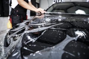 Close Up Of Paint Protection Film Installation On Front Bumper.